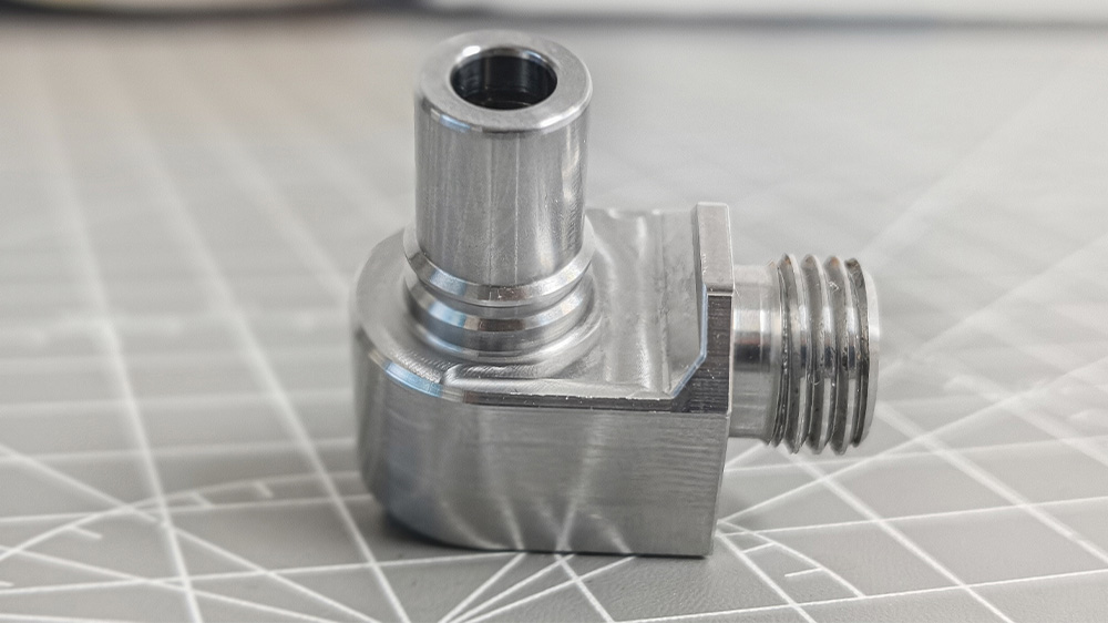 Finished multi-feature small metal part machined on dual-turret CNC machine with indexing chuck